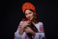 Young women in the red kokoshnik holding cock bird on black background. Russian fairytale.Studio shot Royalty Free Stock Photo