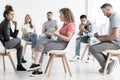 Young woman resolving problem with rebellious friend during group therapy with counselor Royalty Free Stock Photo