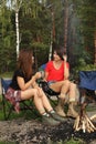 Young women resting on chairs in wilderness