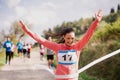 Young woman runner crossing finish line in a race competition in nature. Royalty Free Stock Photo