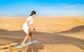 Young women sand surfing at the sand dunes of Dubai United Arab Emirates