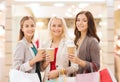 Young women with shopping bags and coffee in mall Royalty Free Stock Photo