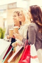 Young women with shopping bags and coffee in mall Royalty Free Stock Photo