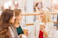 Young women with shopping bags and coffee in mall Royalty Free Stock Photo