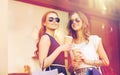 Young women with shopping bags and coffee at shop Royalty Free Stock Photo