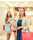 Young women with shopping bags and money in mall Royalty Free Stock Photo