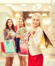 Young women with shopping bags and money in mall Royalty Free Stock Photo