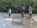 Young women on side of Alaskan river in waders salmon fishing