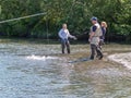 Young women on side of Alaskan river in waders salmon fishing