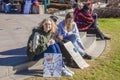 Young women sit at womens march with signs - one girl smiles at camera - sign- I`m with her - Let us speak Royalty Free Stock Photo