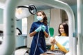 The beautiful young woman is at the dentist. She sits in the dentist`s chair and the dentist carefully examines the patient`s