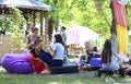 Young women sitting on beanbags applying color on faces of clients