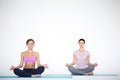 Young women sitting in lotus position indoors on white Royalty Free Stock Photo