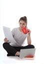 Young women is sitting on white background with laptop, cup, books and papers. Student girl studying, freelances is working.