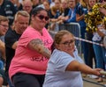 Young women with slight overweight and strained facial expression at the fun championship in bus pulling