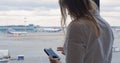 Woman texting on cell and looking at airport area Royalty Free Stock Photo