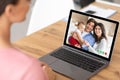 Young woman speaking to cheerful family with cute baby online, using laptop to communicate with her friends from home Royalty Free Stock Photo