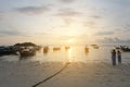 Young women take photos surise with a boat by a camera phone on