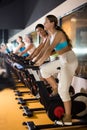 Woman taking indoor cycling class at gym