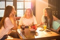Young women talking and having fun in cafe. Royalty Free Stock Photo