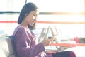 Young women texting on mobile phone waiting for flying at airport window