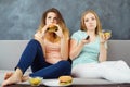 Young women with tv remote eating fast food Royalty Free Stock Photo