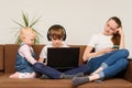 Young woman using smartphone while kids watch in laptop. Lazy bad nanny