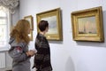 Young women visitors looking at paintings at the exhibition hall. National Museum Kyiv Art Gallery. Kyiv, Ukraine