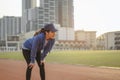 Young women warm up body after running jogging on the running track around the football field.