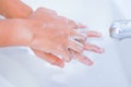 young women washing hands with soap rubbing fingers and skin under faucet water flows on white basin for pandemic prevention Royalty Free Stock Photo