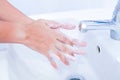 Young women washing hands with soap rubbing fingers and skin under faucet water flows on white basin for pandemic prevention Coron Royalty Free Stock Photo