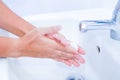 young women washing hands with soap rubbing fingers and skin under faucet water flows on white basin for pandemic prevention Royalty Free Stock Photo