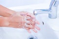 young women washing hands with soap rubbing fingers and skin under faucet water flows on white basin Royalty Free Stock Photo