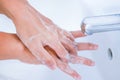 young women washing hands with soap rubbing fingers and skin under faucet water Royalty Free Stock Photo