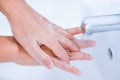 young women washing hands with soap rubbing fingers under faucet water flows for pandemic prevention covid-19 Royalty Free Stock Photo