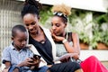 Young women watching a little boy handle a cell phone. Royalty Free Stock Photo