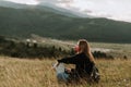 Young women wearing mask, sitting in the field and holding a laptop Royalty Free Stock Photo