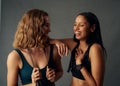 Young woman in sports bra holding jump rope while laughing with friend Royalty Free Stock Photo