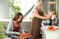 Young woman in wheelchair cooking together with her mother Royalty Free Stock Photo