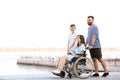 Young woman in wheelchair with her family walking outdoors Royalty Free Stock Photo