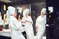 Young women in white bathrobe in bathroom at a spa party Royalty Free Stock Photo