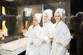 Young women in white bathrobe in bathroom at a spa party Royalty Free Stock Photo