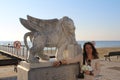 Young women with Winged Lion statue at Foinikoudes promenade, Larnaca, Cyprus Royalty Free Stock Photo