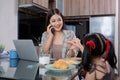 The young woman works from home, raises her daughter, and discusses work with co-workers on the phone and online. Royalty Free Stock Photo