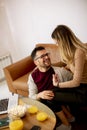 Young woman and young man using laptop while sitting by sofa at home Royalty Free Stock Photo