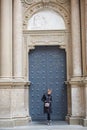 Young wonan poses in front of the Santa Maria de Montserrat Abbey, Catalonia, Spain.