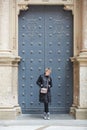 Young wonan poses in front of the Santa Maria de Montserrat Abbey, Catalonia, Spain.