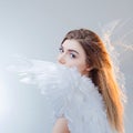 Young, wonderful blonde girl in the image of an angel with white wings. Royalty Free Stock Photo