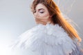 Young, wonderful blonde girl in the image of an angel with white wings. Royalty Free Stock Photo