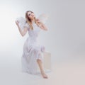 Young, wonderful blonde girl in the image of an angel with white wings. Royalty Free Stock Photo